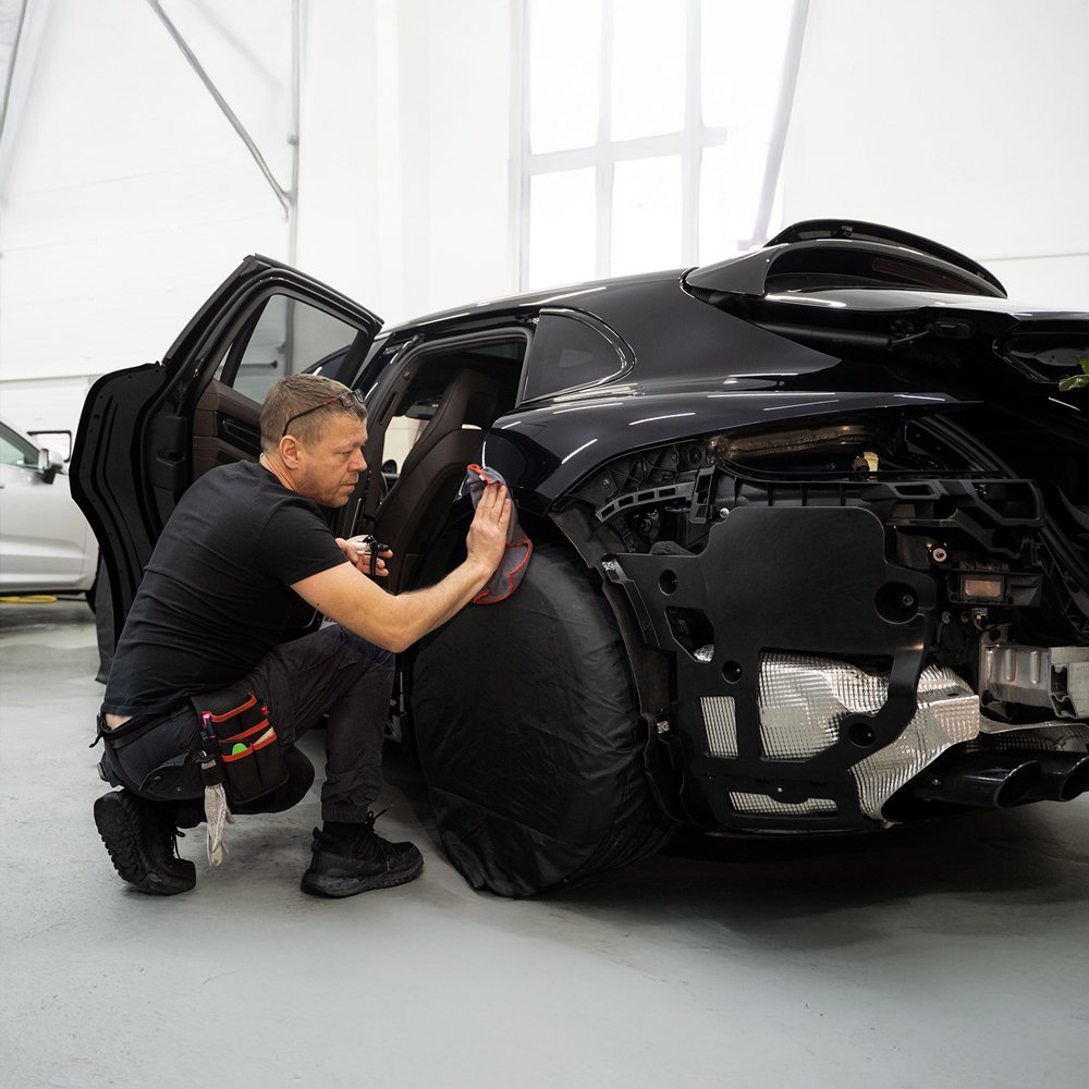Black luxury vehicle fully restored inside Toronto collision repair facility.